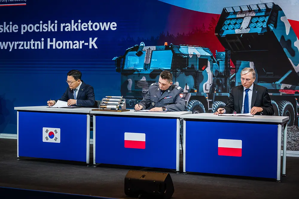 Korean and Polish officials and Hanwha Aerospace executives sign the Chunmoo Homar-K contract during the ceremony.