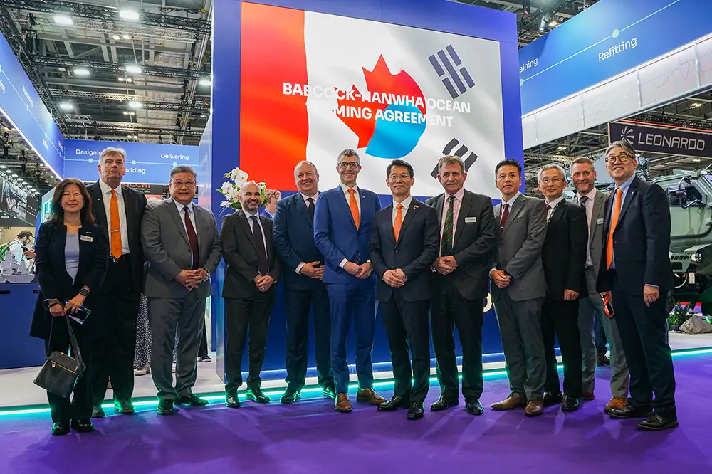 Representatives from Hanwha Ocean and Babcock Canada stand together at a teaming agreement signing event.