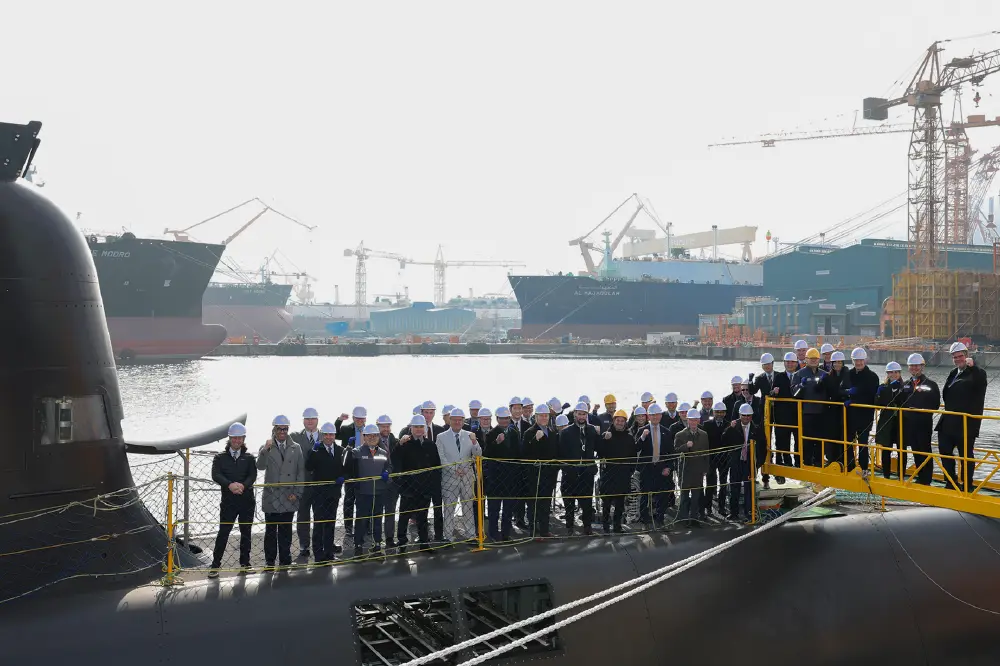 Leaders from both Canadian shipyards and Hanwha Ocean pose for a photo at shipyard. 