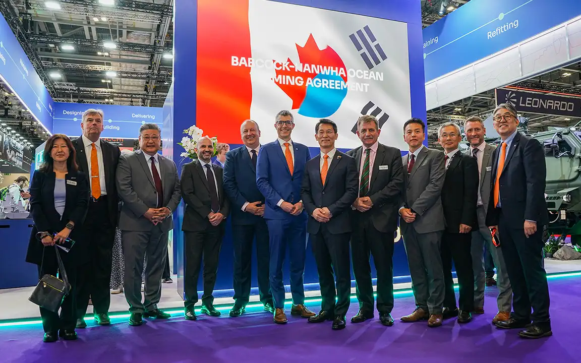 Representatives from Hanwha Ocean and Babcock Canada stand together at a teaming agreement signing event.