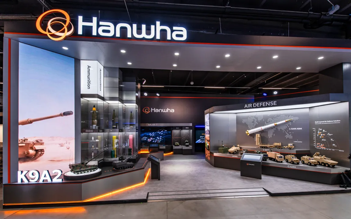 A large Hanwha booth featuring the K9A2, an ammunitions exhibit, and an air defense exhibit.